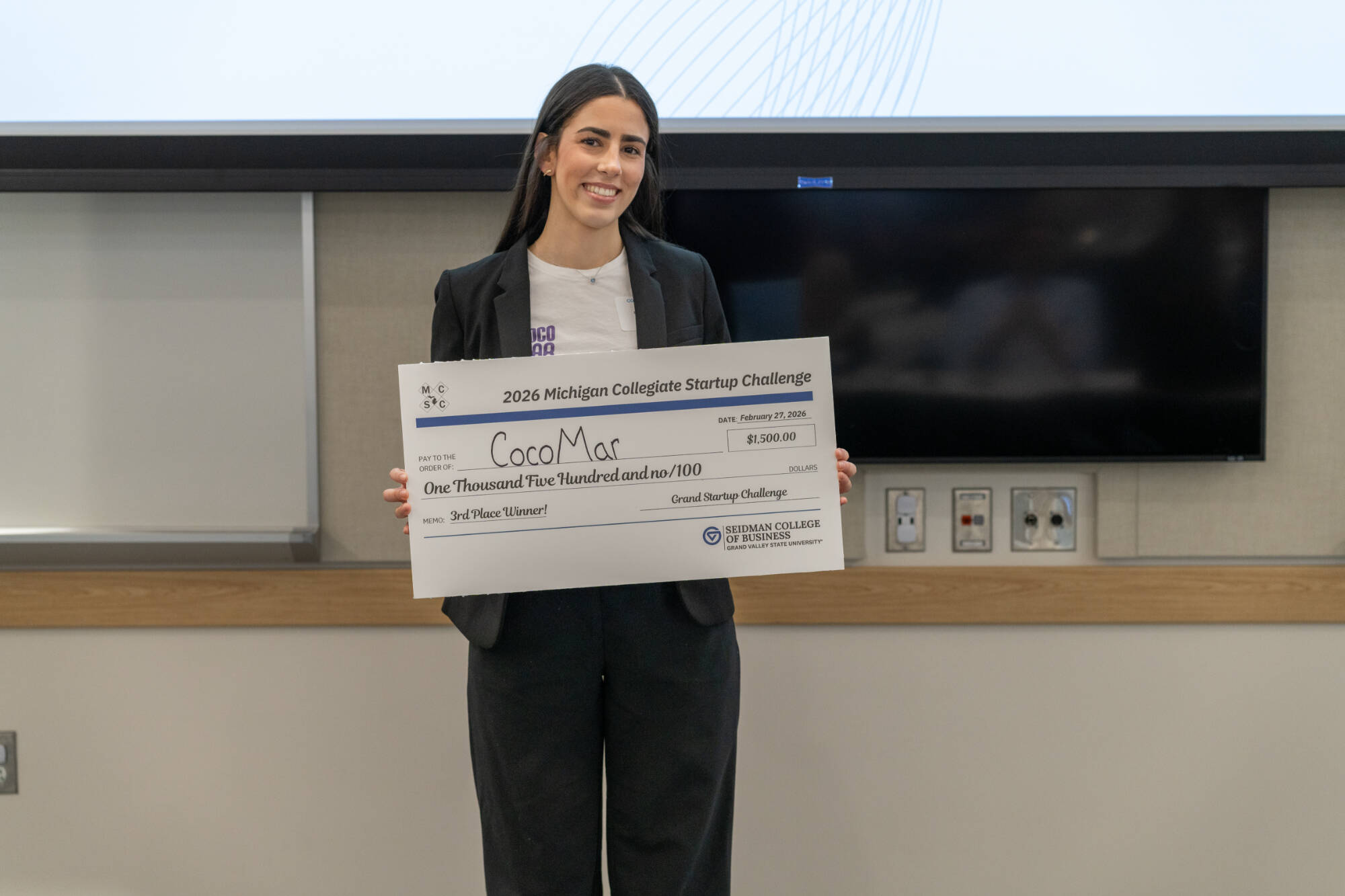 Representative of CocoMar with their prize check